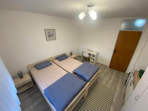 1 dormitorio con 1 cama con almohadas azules en Apartman Valentic, en Vinkovci