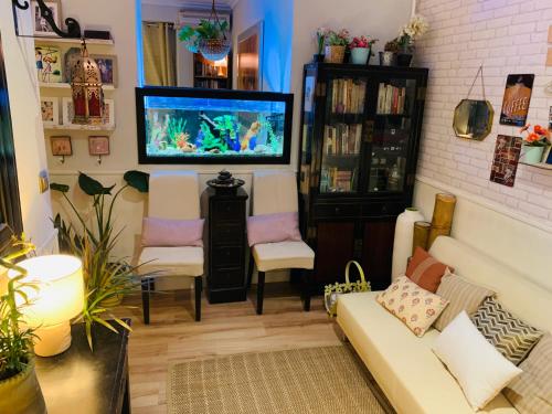ein Wohnzimmer mit einem Sofa und einem TV in der Unterkunft Casa Pepita Gutiérrez in Sevilla