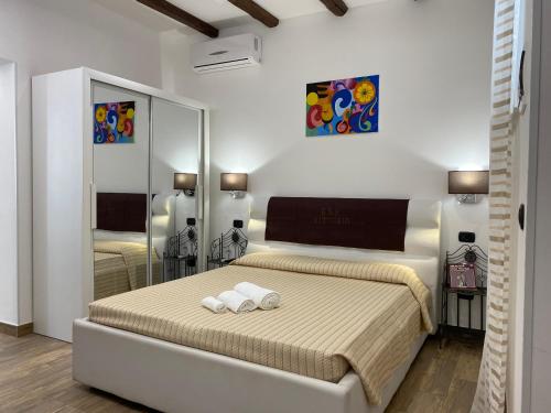 シラクーサにあるAppartamenti Vittoriaのベッドルーム1室(ベッド1台、タオル2枚付)