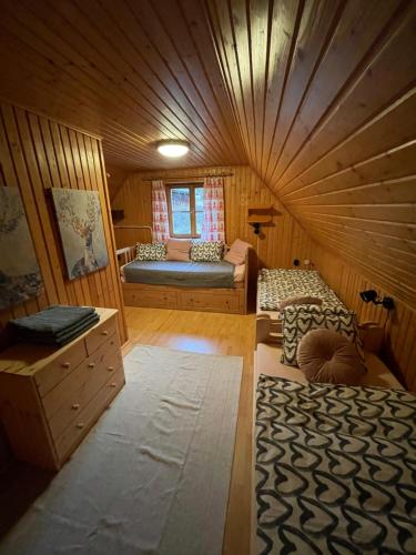 a room with two beds in a wooden room at Chalupa Čičmany in Čičmany