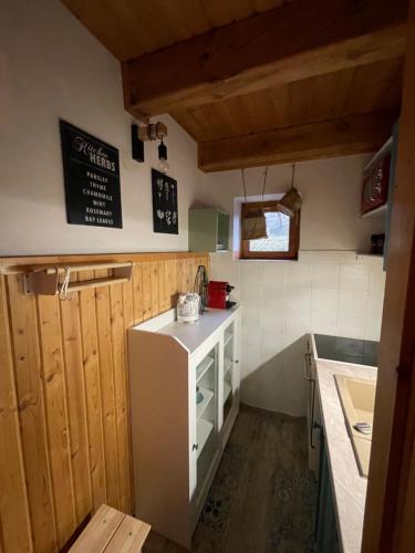 a small kitchen with a white refrigerator and a counter at Chalupa Čičmany in Čičmany