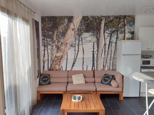 ロンス・レ・バンにあるMaison RONCE LES BAINSのソファ付きのリビングルーム、木の壁画