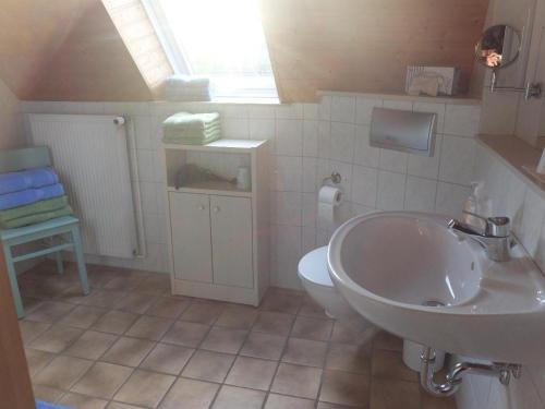 a bathroom with a sink and a toilet at Ferienwohnung-Strandkorb in Ulsnis