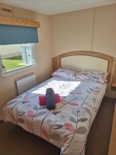 ein Schlafzimmer mit einem Bett mit Hut darauf in der Unterkunft Meadow Lakes 39 in Skegness