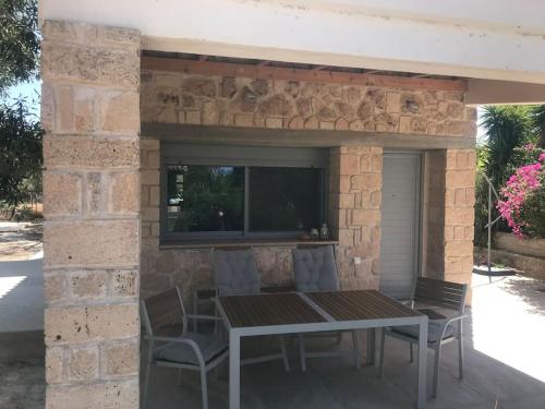a stone wall with a table and chairs and a television at Πέτρινη κατοικία στην Αίγινα - Stone House in Aigina in Khlóï