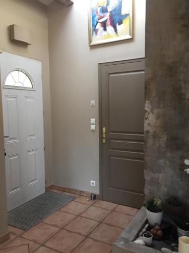 un couloir avec une porte et du carrelage dans l'établissement La Villa Des Cigales, à Saint-Jean-de-Védas