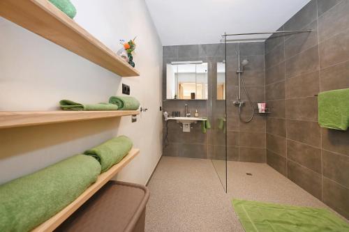 y baño con ducha y toallas verdes. en Ferienhof Landerleben, en Egg