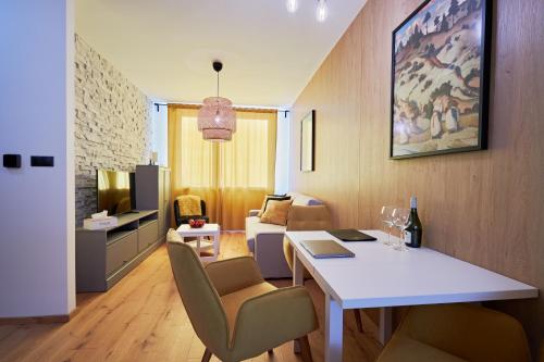 a room with a table and chairs and a living room at RV Apartment Jantár in Starý Smokovec