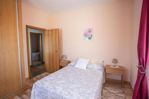 a small bedroom with a bed and a door at Apartamento Teresa in Cambados