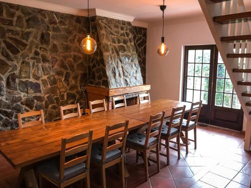 a dining room with a wooden table and chairs at The Far End Surf House - Surf & Yoga Holidays in Lourinhã