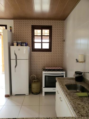 a kitchen with a white refrigerator and a sink at Casa com 3 quartos no Vivendas de Lençóis in Lençóis