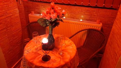 a table with a vase of flowers and a candle at Vila Magica in Constanţa