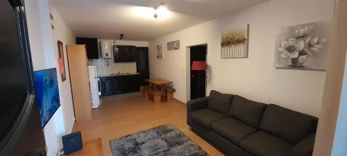 a living room with a couch and a kitchen at Apartment by the Beach Praia da Areia Branca in Lourinhã