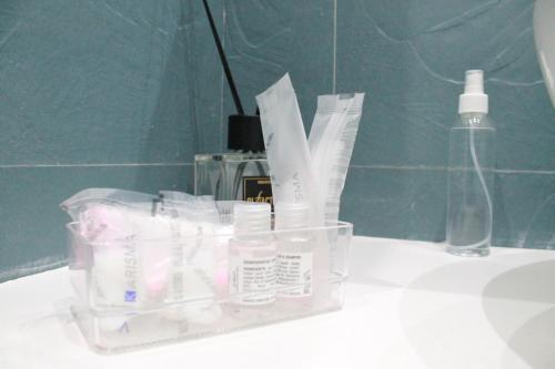 a plastic container of toothpaste and a bottle on a sink at Mascalzone latino luxury rooms in Naples