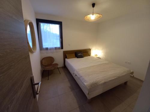 a small bedroom with a bed and a window at Appartement Les Vallons au pied des pistes in Ancelle