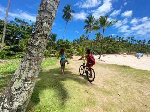 two people riding a bike on the beach at Maré Mansa Pousada e Hostel in Itacaré