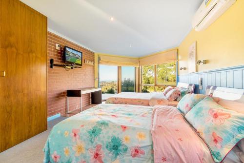 a bedroom with a bed and a tv at Apollo Panorama Guesthouse in Apollo Bay