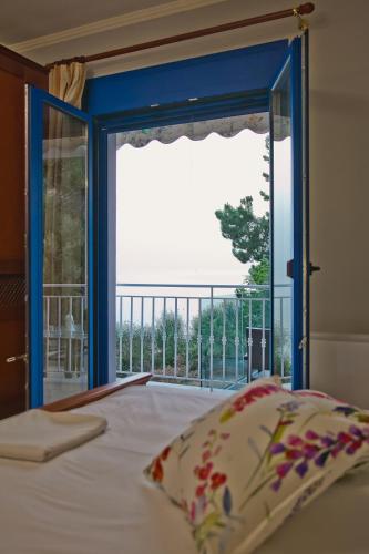 a bedroom with a bed and a large window at Villa Niki in Plataria