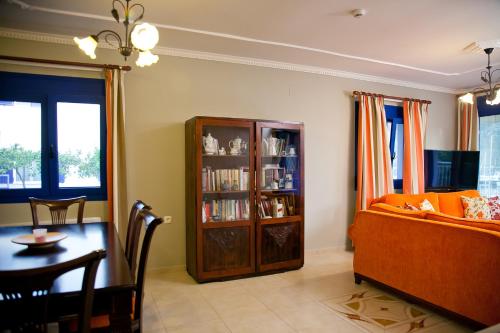 a living room with a table and a couch and a book shelf at Villa Niki in Plataria