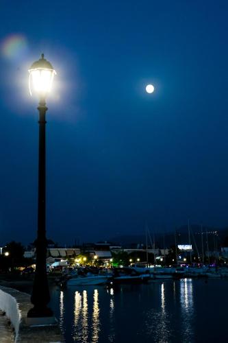 a light pole next to a body of water at night at Villa Niki in Plataria