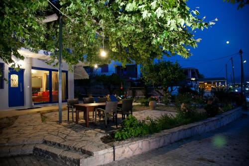 a patio with a table and chairs at night at Villa Niki in Plataria