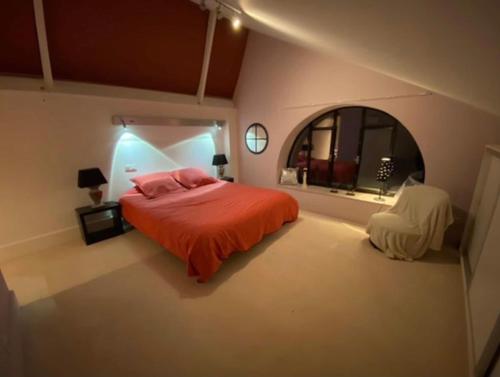 a bedroom with a bed and a round mirror at Le jacuzzi de Marie in Tourcoing