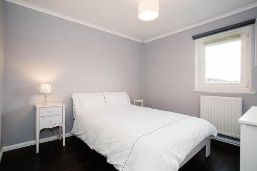 Un dormitorio con una cama blanca y una ventana. en 2 DoubleBed Rooms Flat in old Aberdeen, near University, en Aberdeen