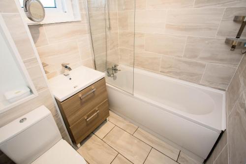 Un baño con inodoro, lavabo y ducha. en 2 DoubleBed Rooms Flat in old Aberdeen, near University, en Aberdeen
