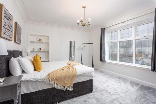 a bedroom with a bed and a desk and a window at Wellington View - Donnini Apartments in Ayr