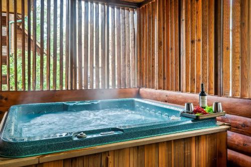 a jacuzzi tub in a wooden room with a bottle of wine at Love Shack in Sevierville