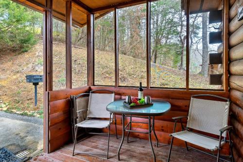 a porch with a table and chairs in a cabin at Love Shack in Sevierville