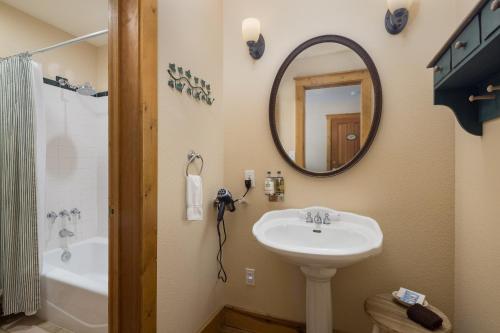 a bathroom with a sink and a mirror and a tub at Sunflower Hill Inn in Moab