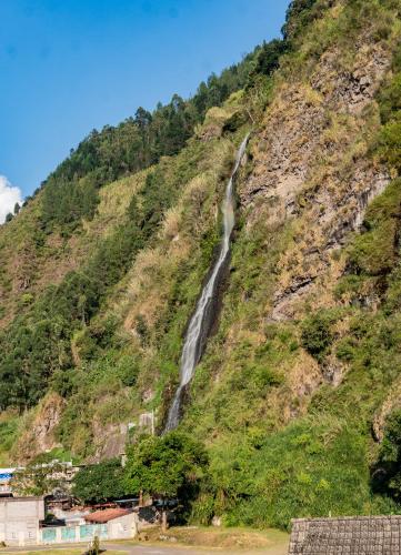 a waterfall on the side of a mountain at Hotel De Mi Pueblo in Baños