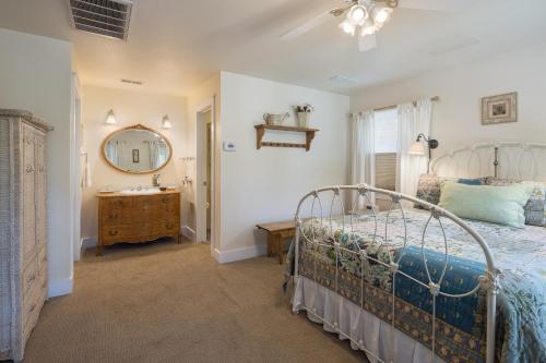a bedroom with a bed and a mirror and a sink at Sunflower Hill Inn in Moab