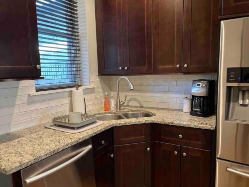 a kitchen with wooden cabinets and a sink and a refrigerator at Trendy West Town Flat - 2 bed / 1.5 bath w parking in Chicago