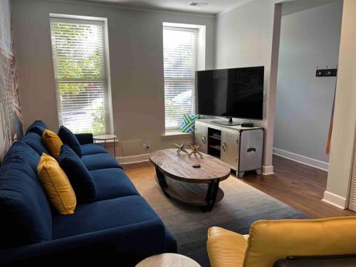 sala de estar con sofá azul y TV en Trendy West Town Flat - 2 bed / 1.5 bath w parking en Chicago