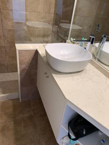 y baño con lavabo blanco y espejo. en Departamento Santos Dumont Punta del Este, en Punta del Este