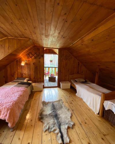 a bedroom with two beds in a wooden room at Leśny Czar in Serock