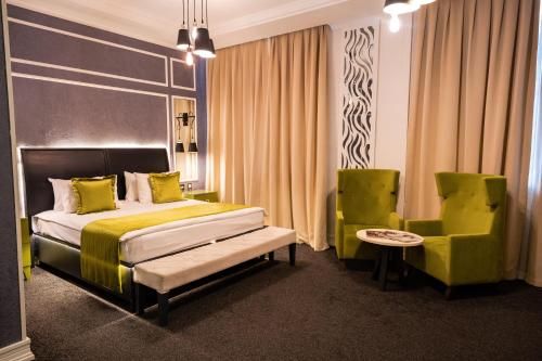 a hotel room with a bed and a chair at Dondar Hotel Formula 1 View in Baku