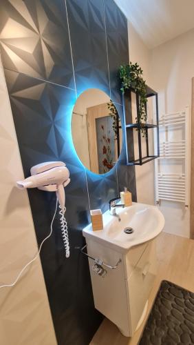 a bathroom with a phone and a sink at Zander Home Apartment in Buşteni