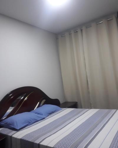 a bedroom with a bed with a blue pillow at Pousada Gameleira in Diamantina