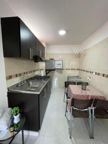 a kitchen with a sink and a table with a tableablish at Apartaestudio San Gil - Hostal Green in San Gil