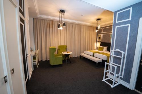 a hotel room with a bed and a chair and a ladder at Dondar Hotel Formula 1 View in Baku