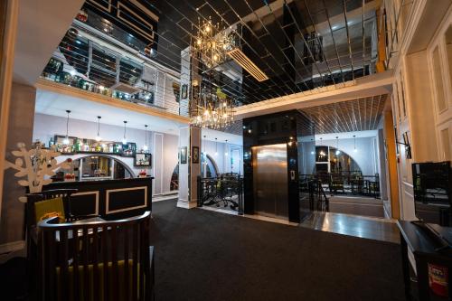 un restaurante con bar con barra y lámpara de araña en Dondar Hotel Formula 1 View en Bakú