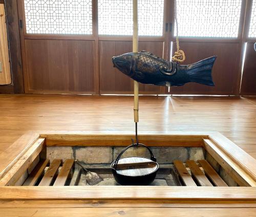 a fish sculpture hanging over a stove with a bowl at hanare in Yamanashi