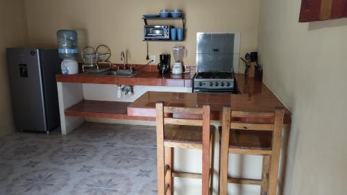 Il comprend une cuisine équipée d'un comptoir avec une cuisinière et un réfrigérateur. dans l'établissement Departamento a 5 minutos de playa Mismaloya, Puerto Vallarta, à Puerto Vallarta