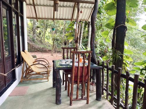 a table and chairs on the porch of a house at Secret Mountain Paradise in Ella