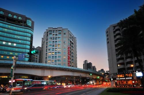 ulica miejska z samochodami i budynkami w nocy w obiekcie Dahu Park Hotel w Tajpej