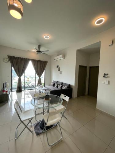 a living room with a glass table and chairs at LakePark Residence KL North in Batu Caves