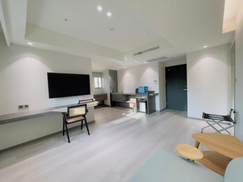 a living room with a flat screen tv on the wall at Dahu Park Hotel in Taipei